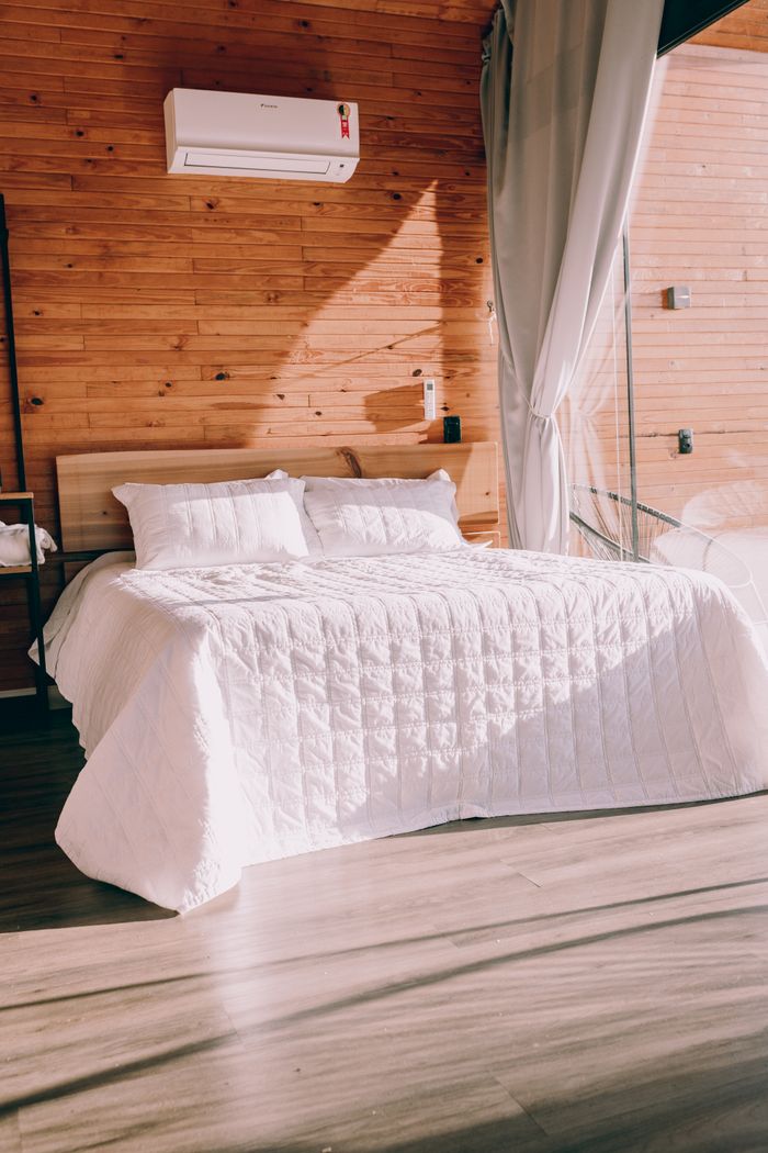 Crafting Captivating Headlines: Your awesome post title goes here A stylish bedroom featuring a double bed with white bedding, wooden walls, and natural light.